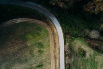 Beautiful drone view of modern van riding on asphalt road near green field on sunny day in countryside — Stock Photo
