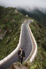 Бородатый фотограф смотрит вдаль на горную дорогу — стоковое фото