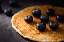 Nahaufnahme köstlicher Pfannkuchen mit reifen Blaubeeren auf dunkelgrauer Tischplatte — Stockfoto