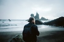 Bearded photographer standing near sea — Stock Photo
