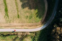 Beautiful drone view of modern van riding on asphalt road near green field on sunny day in countryside — Stock Photo
