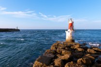 Lighthouse on rocky coastline — Stock Photo