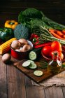 Sortiment an frischem rohem Gemüse und Utensilien auf hölzernem Küchentisch — Stockfoto