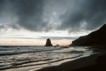 Одинокий скала в море в облачный день — стоковое фото