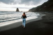 Donna scalza che corre vicino al mare ondeggiante — Foto stock