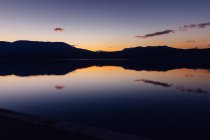 Мальовничий вид на чудове сонячне небо над гірським хребтом і тихою водою — стокове фото