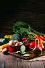 Sortiment an frischem rohem Gemüse und Utensilien auf hölzernem Küchentisch — Stockfoto