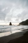 Scogliera solitaria in mare il giorno nuvoloso — Foto stock