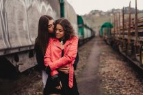 Long haired man hugging and kissing woman near train — Stock Photo