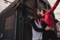 Довгошерстий чоловік обіймає і цілує жінку біля поїзда — стокове фото