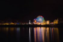 Ferris wheel on city embankment in night time — Stock Photo