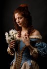 Donna barocca con gli occhi chiusi che tiene mazzo di fiori . — Foto stock