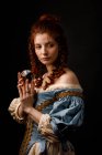 Barockfrau schaut weg, während sie magische Glaskugel in der Hand hält. — Stockfoto