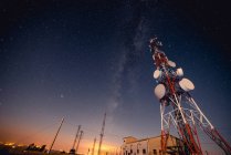 Dal basso alta torre radio moderna situata contro il maestoso cielo stellato in splendida notte — Foto stock