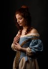 Beautiful woman in medieval clothing posing on black background. — Stock Photo