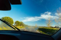 Vista incrível da estrada do campo de asfalto e natureza majestosa no dia ensolarado através do pára-brisa limpo do carro moderno — Fotografia de Stock