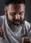 Экспрессивный парикмахер стрижет бороду — стоковое фото
