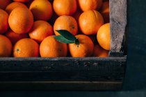 Свежие апельсины в старой деревянной коробке — стоковое фото