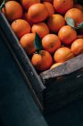Свежие апельсины в старой деревянной коробке — стоковое фото