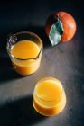 Jugo de naranja en vasos sobre fondo oscuro — Stock Photo
