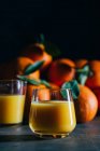 Orangensaft in Gläsern auf dunklem Hintergrund — Stockfoto