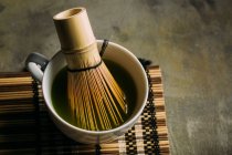 Primo piano della preparazione del tè matcha con frusta di bambù . — Foto stock