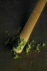Close-up of green matcha tea powder on little spoon. — Stock Photo