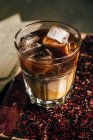 Cold espresso coffee in glass on old shabby book — Stock Photo