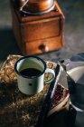 Гаряча кава в емальованій чашці на старих пухнастих книгах — стокове фото