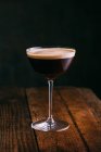 Espresso martini cocktail served in glass on wooden table — Stock Photo