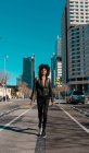 Femme aux cheveux afro marchant dans les rues d'une grande ville — Photo de stock