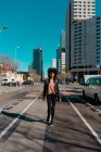 Mulher com cabelo afro andando pelas ruas de uma grande cidade — Fotografia de Stock