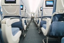 Passagem estreita em meio a assentos confortáveis dentro da cabine de aeronaves modernas — Fotografia de Stock