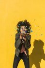 Schwarze Frau mit Afrohaaren wirft Konfetti, um einen ganz besonderen Tag zu feiern — Stockfoto