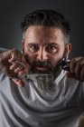 Ausdrucksstarker Barbier schneidet Bart — Stockfoto