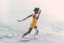На вигляд афроамериканського підлітка з іграшками, що пливуть морем на ямайці. — стокове фото