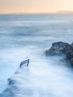 Чудесное туманное море, машущее у грубого каменистого берега — стоковое фото