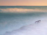 Meraviglioso mare nebbioso ondeggiante vicino grezzo riva pietrosa — Foto stock