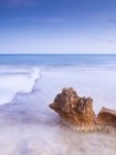 Удивительные камни на берегу у воды и голубого неба — стоковое фото