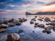 Beautiful view of bright cloudy evening sky over majestic sea and rocky shore in spectacular nature — Stock Photo