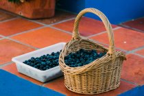 Basket and tray with black olives — Stock Photo