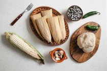 Teig in der Nähe von Maisschalen und Gewürzen für Tamales — Stockfoto