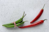 Frische rote und grüne würzige Chilischoten auf weißem Hintergrund — Stockfoto