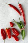 Fresh red and green spicy chilli peppers on white background — Stock Photo