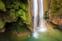 Turquoise water in reservoir with waterfall and green rocks, Navarra — Stock Photo