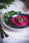 Homemade beetroot hummus on plate with herbs — Stock Photo