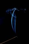 Вереницы ярко-синего дыма на черном фоне — стоковое фото