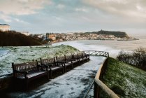 Rangée de bancs vides et passerelle de givre dans la baie du Yorkshire, Angleterre — Photo de stock