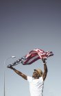 Счастливый черный человек с развевающимся американским флагом — стоковое фото