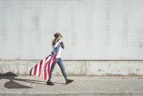 Счастливый черный человек с развевающимся американским флагом — стоковое фото